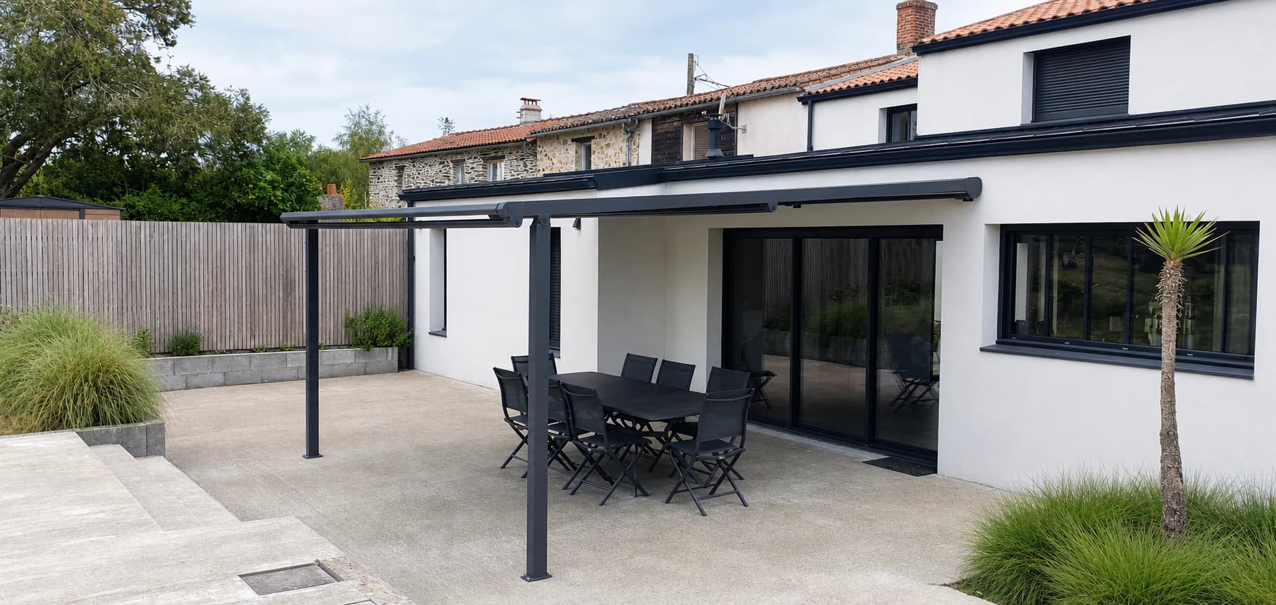 Pergola anthracite installée sur la terrasse d'une maison rénovée