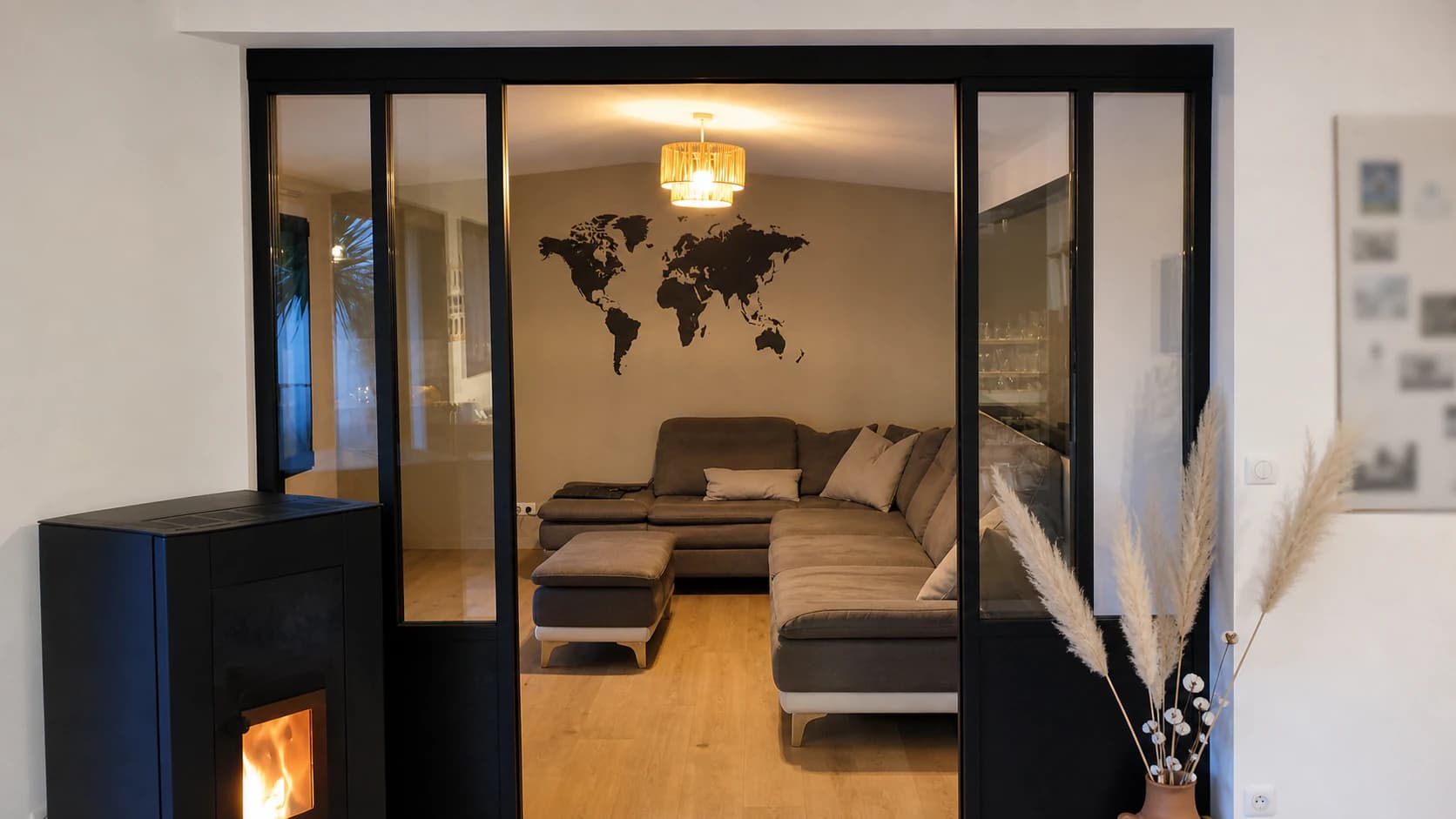 Verrière d'atelier en acier noir sur mesure ouvrant sur une véranda et un jardin