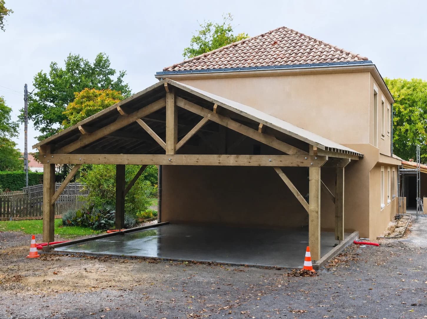 Charpente traditionnelle en bois d'un carport adossé à une maison, réalisée par Linéaire Menuiserie