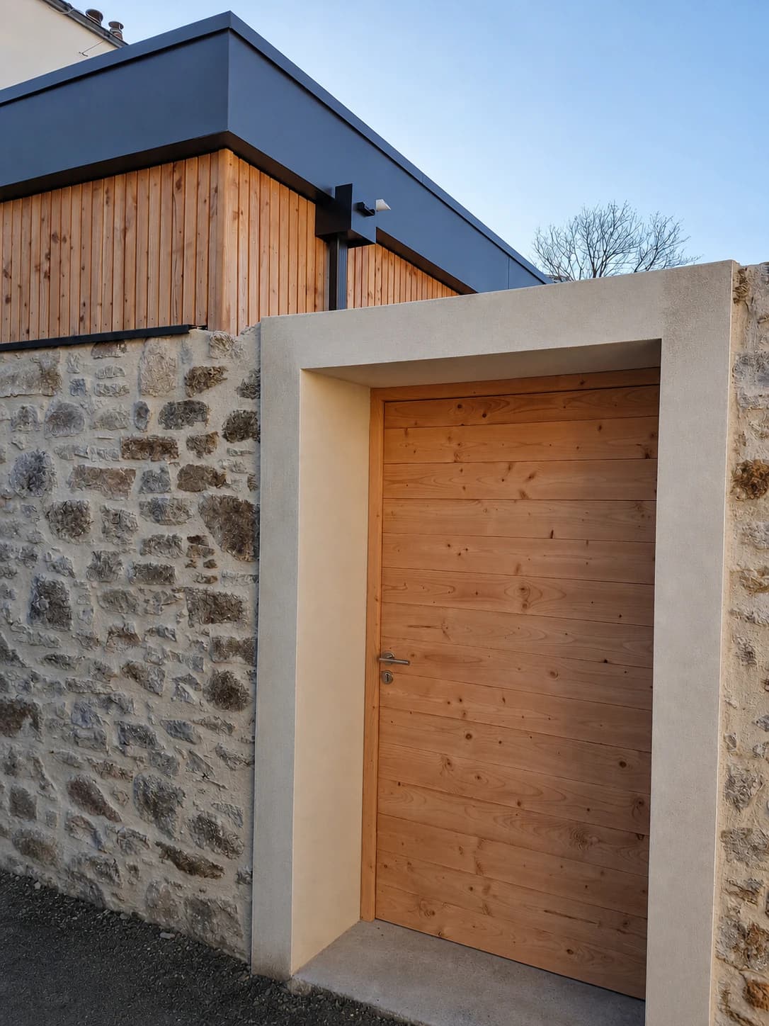 Porte extérieure en bois sur mesure intégrée à un mur en pierre