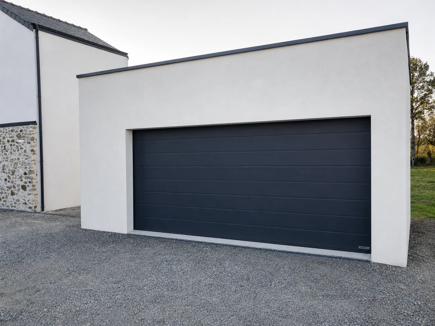 Porte de garage sectionnelle anthracite installée sur une maison contemporaine