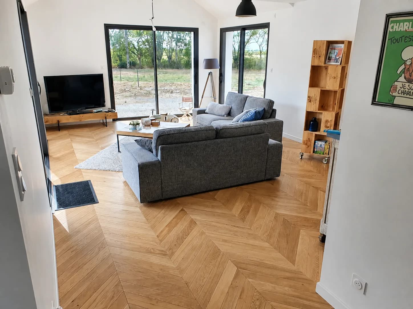 Séjour avec parquet chêne en point de Hongrie et grandes baies vitrées, réalisé par Linéaire Menuiserie